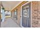 Inviting front door with decorative wreath and a covered porch with brick pillars at 206 Prescott St, Locust Grove, GA 30248