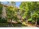Exterior view showcasing the townhome nestled among mature trees and verdant landscaping at 217 Knob Hills Cir, Decatur, GA 30030
