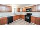 A kitchen featuring wood cabinets, black appliances, tile backsplash, and wood-look flooring at 4391 Sandy Plains Rd, Marietta, GA 30066
