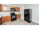 A kitchen featuring wood cabinets, black appliances, tile backsplash, and wood-look flooring at 4391 Sandy Plains Rd, Marietta, GA 30066