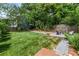 Spacious backyard featuring green grass, a firepit area, privacy fence, and a stone walkway, ideal for outdoor entertaining at 132 Olympic Pl, Decatur, GA 30030