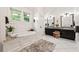 Primary bathroom with dual vanities, soaking tub, and bright windows at 132 Olympic Pl, Decatur, GA 30030