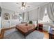 Bright bedroom with hardwood floors, a cozy bed, two windows with white curtains, and light blue walls at 132 Olympic Pl, Decatur, GA 30030
