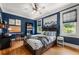 Cozy bedroom with blue walls, hardwood floors, comfortable bed, and natural light from two windows at 132 Olympic Pl, Decatur, GA 30030