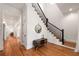 Bright foyer with hardwood floors, staircase, and stylish console table with a round mirror at 132 Olympic Pl, Decatur, GA 30030