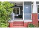 Cozy front porch featuring a porch swing, brick accents, and space for relaxation at 132 Olympic Pl, Decatur, GA 30030