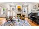 Stylish living room featuring hardwood floors, a fireplace, a grand piano, and ample natural light at 132 Olympic Pl, Decatur, GA 30030