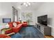 Bright living room with orange sofa, area rug, and television at 132 Olympic Pl, Decatur, GA 30030