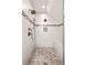Walk-in shower with pebble floor, subway tile and bronze fixtures at 132 Olympic Pl, Decatur, GA 30030