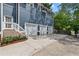 Exterior view showcasing a three-car garage, backyard access, and the home's blue siding with white trim at 132 Olympic Pl, Decatur, GA 30030
