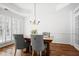 Bright dining room with hardwood floors, a chandelier, and a wooden table with gray upholstered chairs at 4044 Kenway Se Pl, Smyrna, GA 30082