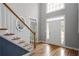 Bright foyer with hardwood floors, a staircase, and a view of the front door and transom window at 4044 Kenway Se Pl, Smyrna, GA 30082