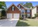 Charming two-story brick home with a well-manicured lawn, two-car garage, and a classic front door at 4044 Kenway Se Pl, Smyrna, GA 30082