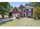 Charming two-story brick home with a well-manicured lawn, mature trees, and a classic front door at 4044 Kenway Se Pl, Smyrna, GA 30082