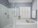 Bright main bathroom featuring a separate glass shower and soaking tub under a window at 4044 Kenway Se Pl, Smyrna, GA 30082