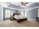 Spacious main bedroom featuring tray ceilings, a ceiling fan, and light-filled windows at 4044 Kenway Se Pl, Smyrna, GA 30082