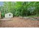 A private backyard with a shed surrounded by lush trees at 502 Knollwood Pl, Woodstock, GA 30188