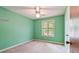 Mint green bedroom with carpeted floors, a ceiling fan, and a large window with outside views at 502 Knollwood Pl, Woodstock, GA 30188