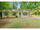 Yellow house with blue shutters and front porch sitting on a grassy lot at 502 Knollwood Pl, Woodstock, GA 30188