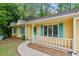 Close-up view of a charming yellow home with a welcoming front porch and blue shutters at 502 Knollwood Pl, Woodstock, GA 30188