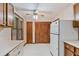 Traditional kitchen with wood cabinets, appliances, ceiling fan, and adjacent access to laundry area at 502 Knollwood Pl, Woodstock, GA 30188