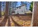 Exterior view of the rear of the house and backyard surrounded by trees at 7000 Woodland Nw Pl, Kennesaw, GA 30152