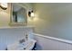 Charming powder room featuring wainscotting, vintage mirror, and modern lighting at 986 Franklin Ridge Ct, Sugar Hill, GA 30518