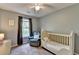 Bedroom featuring hardwood floors, natural light, crib and comfy chair at 986 Franklin Ridge Ct, Sugar Hill, GA 30518
