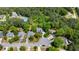 A high angle aerial shot shows residences on a cul-de-sac surrounded by dense lush trees and neighborhood tennis courts at 1156 Cotton Gin Ct, Lawrenceville, GA 30045