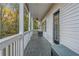 View of the covered porch featuring wood floors, ceiling fan and wooded views at 1156 Cotton Gin Ct, Lawrenceville, GA 30045