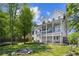 View of the back of the home featuring a porch, backyard and mature trees at 1156 Cotton Gin Ct, Lawrenceville, GA 30045