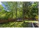 View of the large backyard featuring a trampoline, landscaping and wooden fence at 1156 Cotton Gin Ct, Lawrenceville, GA 30045