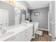 Bright bathroom features a double sink vanity with white cabinets and wood-look flooring at 1156 Cotton Gin Ct, Lawrenceville, GA 30045