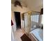 Bright bathroom with a glass-enclosed shower, a soaking tub, and white tile flooring at 2246 Carrington Dr, Ellenwood, GA 30294