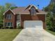 Charming two-story brick home with a well-manicured lawn and a two-car garage at 2246 Carrington Dr, Ellenwood, GA 30294