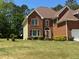 Attractive brick house presenting a two-car garage and a sprawling, verdant lawn at 2246 Carrington Dr, Ellenwood, GA 30294