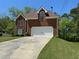 Classic brick residence featuring a two-car garage and a neatly kept front lawn at 2246 Carrington Dr, Ellenwood, GA 30294