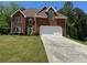 Traditional brick home with a well-maintained lawn and an attached two-car garage at 2246 Carrington Dr, Ellenwood, GA 30294