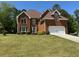 Lovely brick home showcasing an attached two-car garage and lush green front yard at 2246 Carrington Dr, Ellenwood, GA 30294