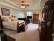 Spacious main bedroom with a ceiling fan, TV, a seating area, and elegant furniture at 2246 Carrington Dr, Ellenwood, GA 30294