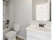 Neutral bathroom with a shower and tub combo, toilet, white vanity, and a silver framed mirror at 3625 New River Ct, Cumming, GA 30040