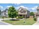 Charming home featuring a well-manicured lawn, stone accents, and a cozy porch, inviting you to relax at 3625 New River Ct, Cumming, GA 30040