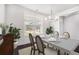 Elegant dining room with dark hardwood floors, wainscoting, table, and a modern chandelier at 5749 Creek Indian Dr, Sugar Hill, GA 30518