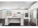 Modern kitchen featuring white cabinets, stainless steel appliances, and a granite-topped island at 5749 Creek Indian Dr, Sugar Hill, GA 30518
