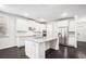 Beautiful white kitchen with stainless steel appliances, granite countertops, and dark hardwood floors at 5749 Creek Indian Dr, Sugar Hill, GA 30518