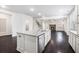 Open-concept kitchen island with granite countertops, stainless steel appliances, and dark hardwood floors at 5749 Creek Indian Dr, Sugar Hill, GA 30518