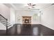 Open-concept living room featuring dark hardwood floors, a stone fireplace, and a ceiling fan at 5749 Creek Indian Dr, Sugar Hill, GA 30518