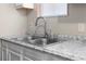 Close-up of the kitchen sink with modern faucet, granite countertop, and window view at 60 Highland Dr, Stockbridge, GA 30281