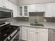 Modern kitchen with stainless steel gas range, microwave, granite countertops, and white cabinets at 6980 Roswell Rd # J6, Atlanta, GA 30328