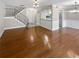 Spacious living room with hardwood floors, staircase, and view of the kitchen and dining area at 6980 Roswell Rd # J6, Atlanta, GA 30328